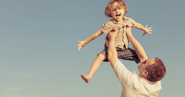 Dad and son playing near a house